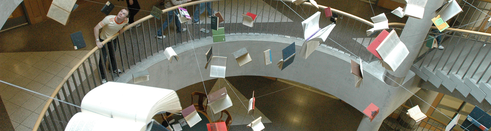Art installation inside Main Stacks Library in which books are suspended in the air throughout the stairwell.
